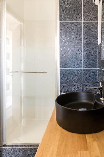 La salle de bains est pourvue d'une baignoire noire et d'une douche. dans l'établissement C'est l'Amour à la plage, à Narbonne-Plage