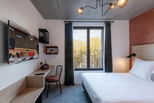 a bedroom with a bed and a desk and a window at Quai Central in Tourcoing