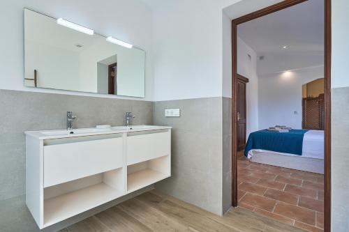 un bagno con lavandino, specchio e letto di Villa Abril a Santanyi