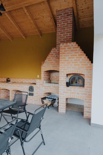 a brick fireplace with tables and chairs in front of it at IoanaGuestHouse in Turda