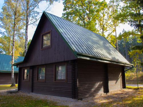 a small cabin with a black roof at Holiday Home Kemp Stříbrný rybník-11 by Interhome in Hradec Králové