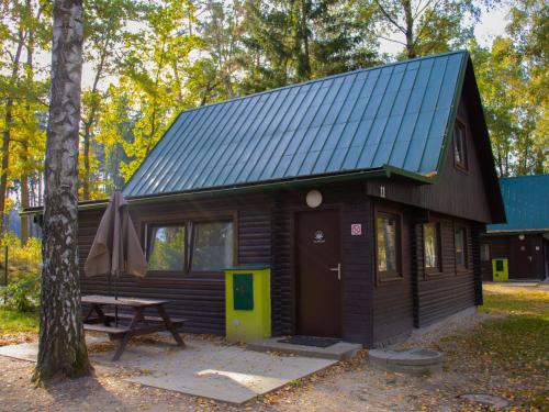 a cabin in the woods with a picnic table at Holiday Home Kemp Stříbrný rybník-11 by Interhome in Hradec Králové