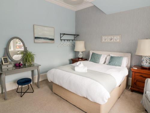 a bedroom with a bed and a table and a mirror at The Old Rectory in Largs