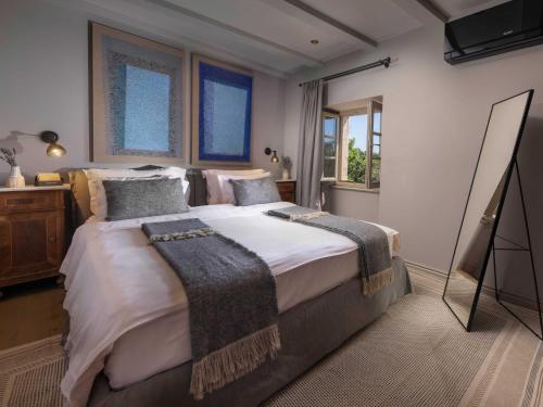a bedroom with a large bed with white sheets and pillows at San Canzian Hotel & Residences - Small Luxury Hotels of the World in Buje