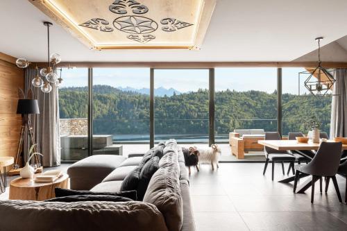 a living room with a couch and a large window at Czorsztyn Prestige Apartamenty in Czorsztyn