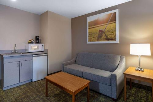 a living room with a couch and a microwave at Days Inn & Suites by Wyndham Madison in Madison