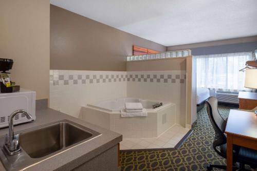 麥迪遜的住宿－南麥迪遜/莫諾納戴斯套房酒店，带浴缸和盥洗盆的酒店浴室