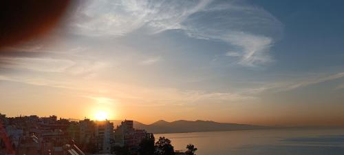 a view of the sun setting over a city at Blue Seaview Suites in Piraeus