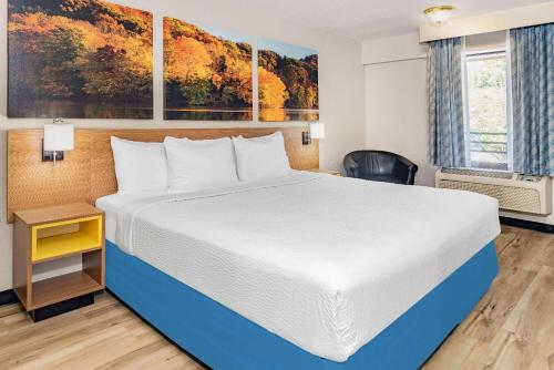 a bedroom with a large bed in a hotel room at Days Inn by Wyndham Spartanburg Waccamaw in Southern Shops