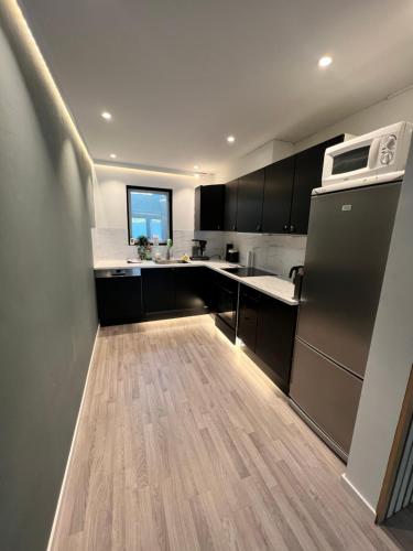 uma cozinha com um frigorífico e um micro-ondas em Fresh apartment near everything ! em Tromsø