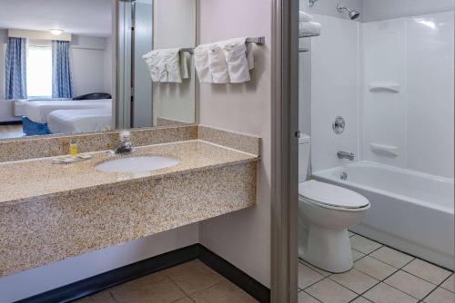 a bathroom with a sink and a toilet at Days Inn by Wyndham Spartanburg Waccamaw in Southern Shops