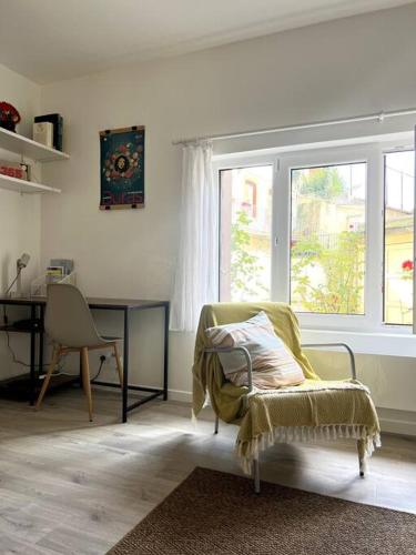 un salon avec une chaise et une fenêtre dans l'établissement Le Rocher Trouville, à Trouville-sur-Mer