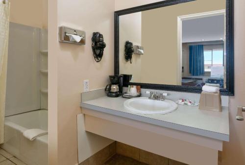 y baño con lavabo y espejo. en Super 8 by Wyndham Vernon, en Vernon