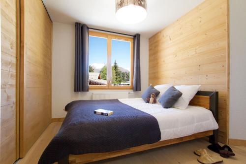 a small child sitting on a bed in a bedroom at Résidence Neige et Soleil by Leavetown Vacations in Les Deux Alpes