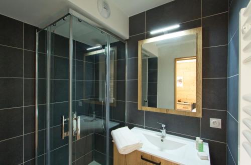 La salle de bains est pourvue d'un lavabo et d'une douche. dans l'établissement Résidence Neige et Soleil by Leavetown Vacations, à Les Deux Alpes