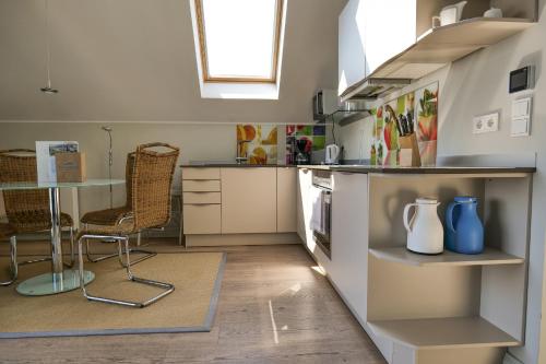 a kitchen with a counter and a table and chairs at Ostsee - Appartement Nr 25 "Godetied" im Strand Resort in Heiligenhafen