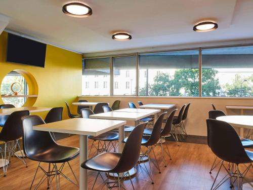 une salle de classe avec des tables, des chaises et des fenêtres dans l'établissement Aparthotel Adagio Access Paris La Villette, à Paris