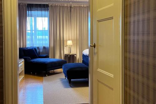 a living room with a blue chair and a couch at Best Western Motala Stadshotell in Motala