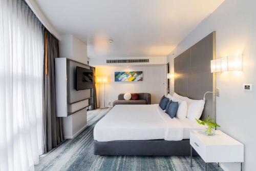 a hotel room with a large bed and a tv at Best Western Sukhumvit 20 in Bangkok