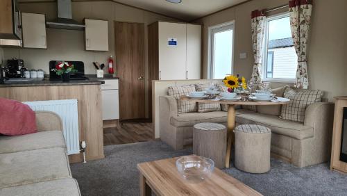 a living room with a table and a kitchen at KMH Caravans at Flamingo Land in Kirby Misperton