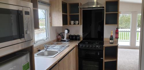a kitchen with a sink and a stove top oven at KMH Caravans at Flamingo Land in Kirby Misperton