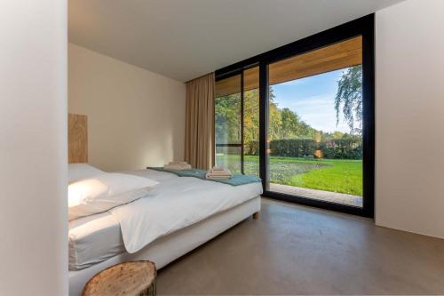 - une chambre avec un lit et une grande fenêtre dans l'établissement Equilodge 't Blommeke - Reconnect with nature, à Bruges