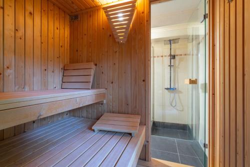 eine Sauna mit einer Bank und einer Dusche darin in der Unterkunft Au Ptit Bois Charmant in La-Roche-en-Ardenne