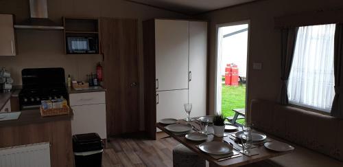 a kitchen with a table with plates on it at KMH Caravans at Flamingo Land in Kirby Misperton
