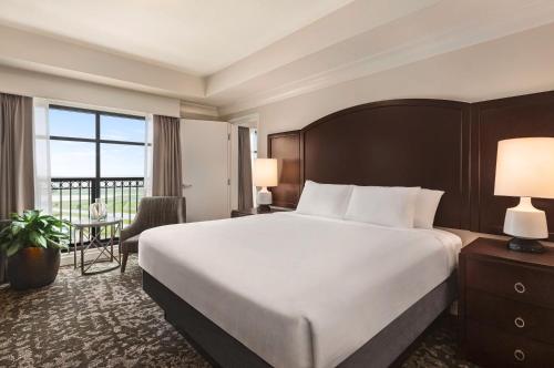 基西米Embassy Suites by Hilton Orlando Lake Buena Vista South的配有一张大床和一张书桌的酒店房间
