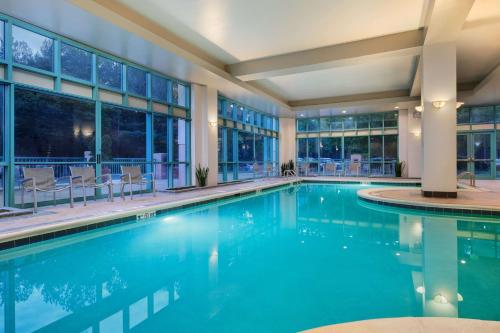 a swimming pool with blue water in a building at Embassy Suites by Hilton Raleigh Durham Research Triangle in Cary