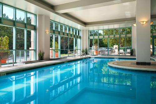 a swimming pool with blue water in a house at Embassy Suites by Hilton Raleigh Durham Research Triangle in Cary