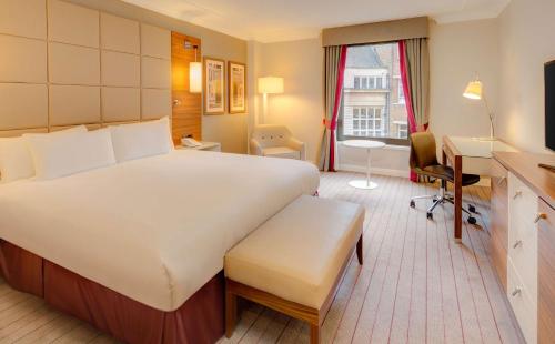 a hotel room with a large bed and a desk at Hilton Cambridge City Centre in Cambridge