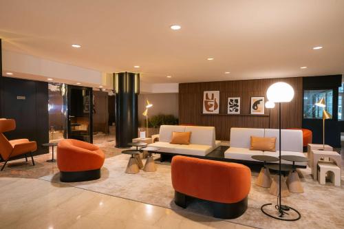 a lobby with couches and chairs in a building at Hilton Paris La Défense in Puteaux