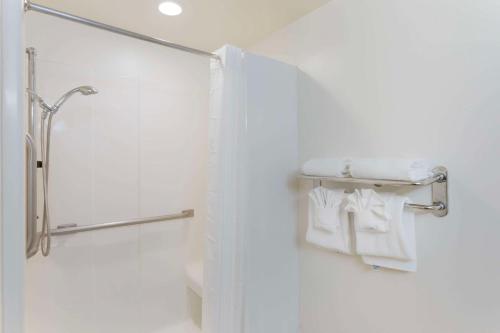 a bathroom with a shower with white towels on a shelf at Comfort Inn Near Grand Canyon in Williams