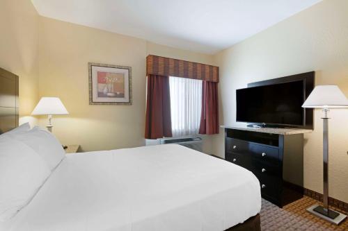 a hotel room with a bed and a flat screen tv at Comfort Inn Near Grand Canyon in Williams