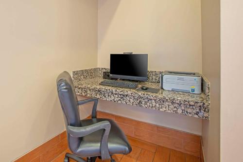 a desk with a computer and a chair in a room at Comfort Inn Near Grand Canyon in Williams
