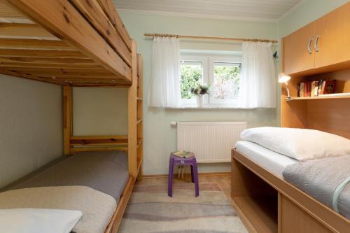 a bedroom with two bunk beds and a purple stool at Ferienhaus Schneider, Snieder's Hoeg in Grömitz