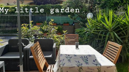 a patio with a table and chairs and a sign that reads my little garden at Fabiola B & B in Marino
