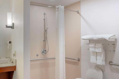 a bathroom with a shower and a toilet and towels at Comfort Suites in Bloomsburg