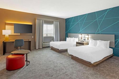 Habitación de hotel con 2 camas y TV de pantalla plana. en Comfort Suites, en Bloomsburg