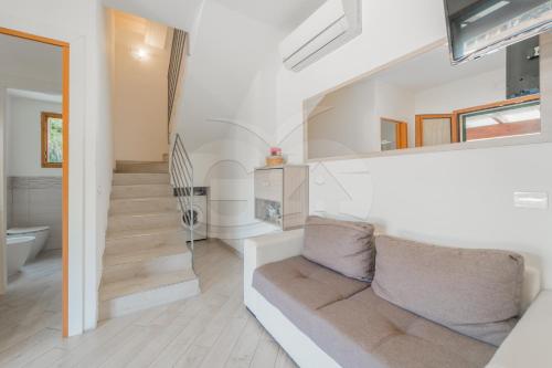 un salon avec un canapé et un escalier dans l'établissement La Perla della Biodola - Goelba, à Portoferraio