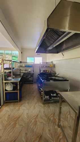 uma grande cozinha com mesas e balcões num quarto em Pulickal Heights Hotel em Entebbe