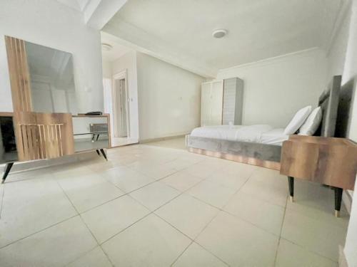 a large white bedroom with a bed and a tiled floor at Résidence de la providence appart Hotel -ODZA in Yaoundé