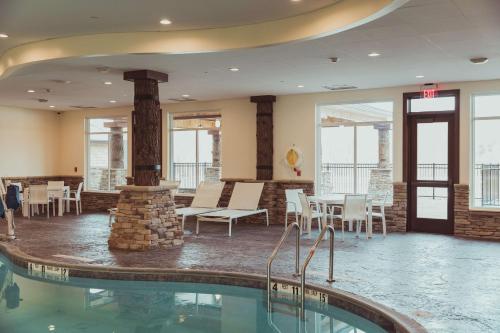 a pool in a hotel with chairs and a table at Tailwater Lodge Altmar, Tapestry Collection By Hilton in Pulaski