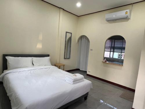 una camera con un letto bianco e una finestra di KP House Bueng Kan a Seka