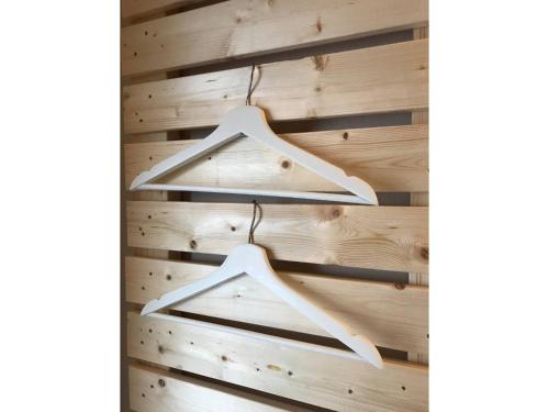 two white hangers hanging on a wooden wall at Enoshima Beach - Vacation STAY 07420v in Fujisawa