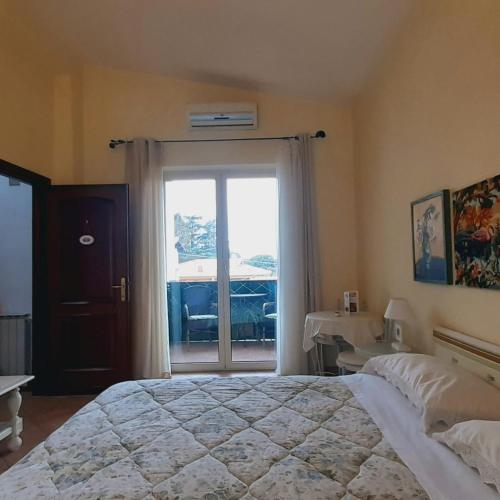 a bedroom with a large bed and a large window at Fabiola B & B in Marino