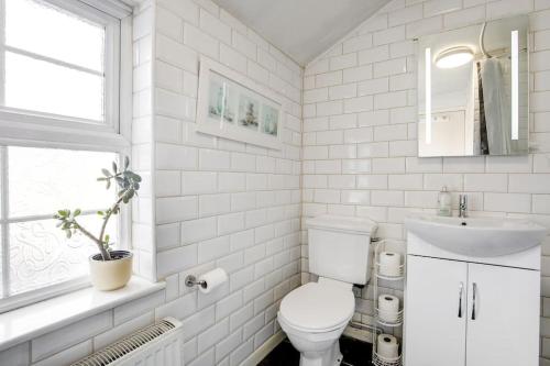 a white bathroom with a toilet and a sink at 2 Bedroom Duplex Apartment in Leicester