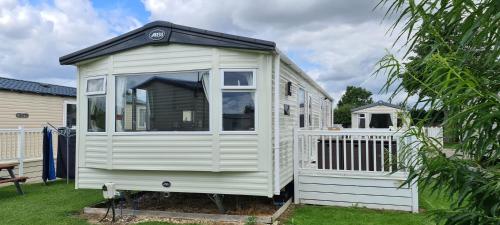 a white tiny house sitting in a yard at KMH Caravans at Flamingo Land in Kirby Misperton