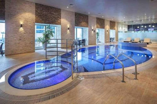 een groot zwembad in een gebouw met een lobby bij Your Dubai Skyline Retreat in Dubai